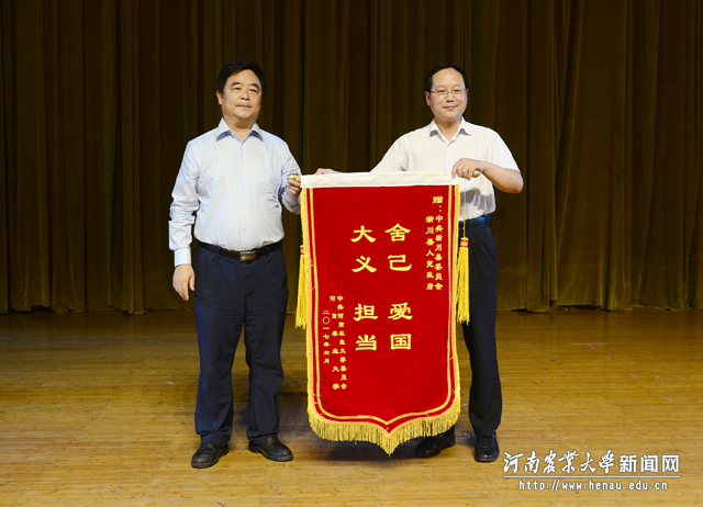校党委副书记、工会主席褚金海向报告团代表赠送锦旗